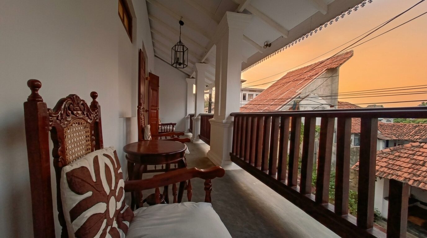 Upper verandah at sunset with lanterns and teak chairs